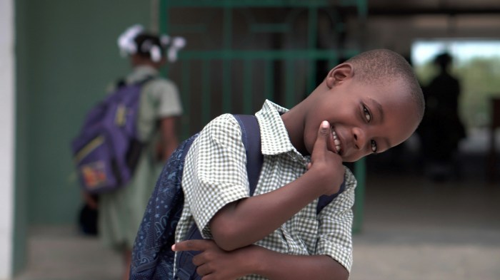 Photo of a little boy smiling with his school backpack on his back