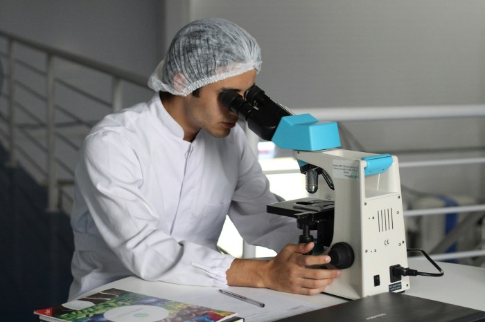 Photo of a man looking into a microscope