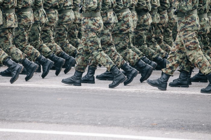 Photo of soldiers marching in camouflage uniforms.