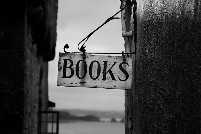 Black and White photo of an old outdoor sign that says, "Books"