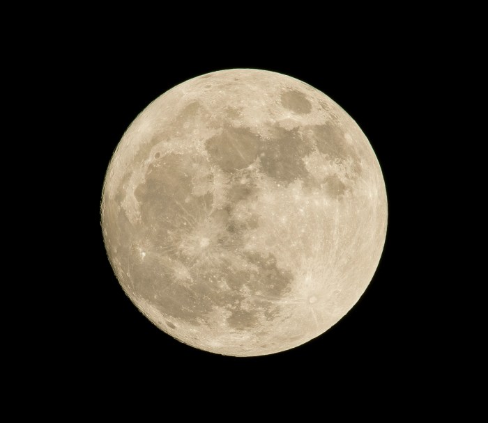 Photo of a beige moon surrounded by total blackness.