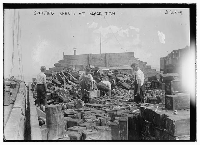 Black and white photo from Library of Congress of men sorting ammunition at the Black Tom Island railyard